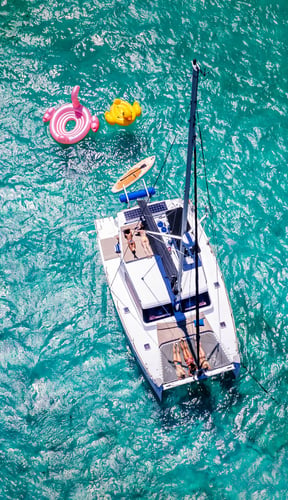 Aerial view of a catamaran sailing over turquoise Caribbean water